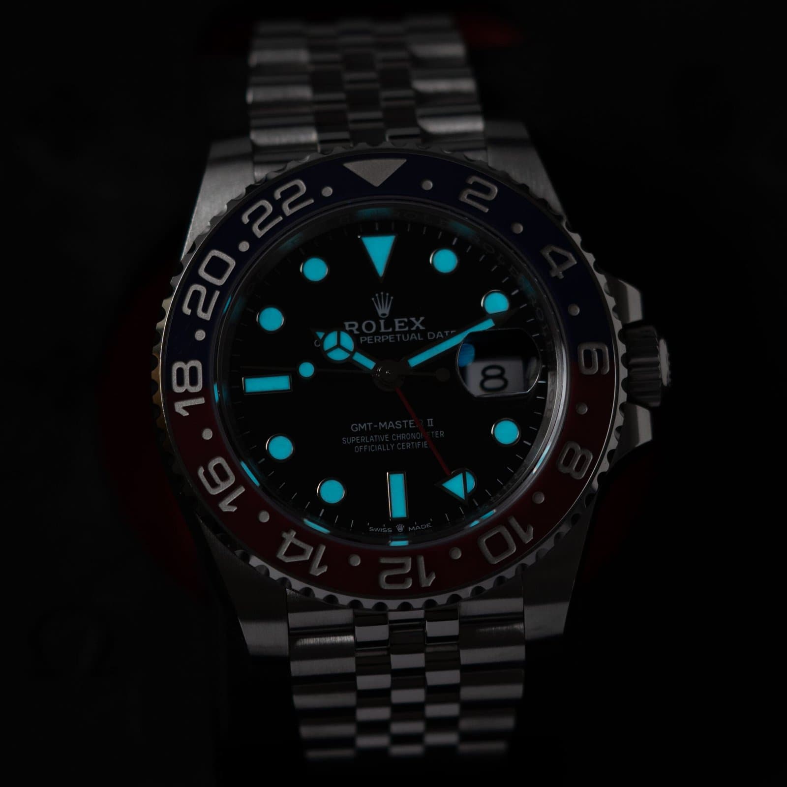 Rolex GMT-Master II Pepsi in steel on a Jubilee bracelet, its lume glowing in low light