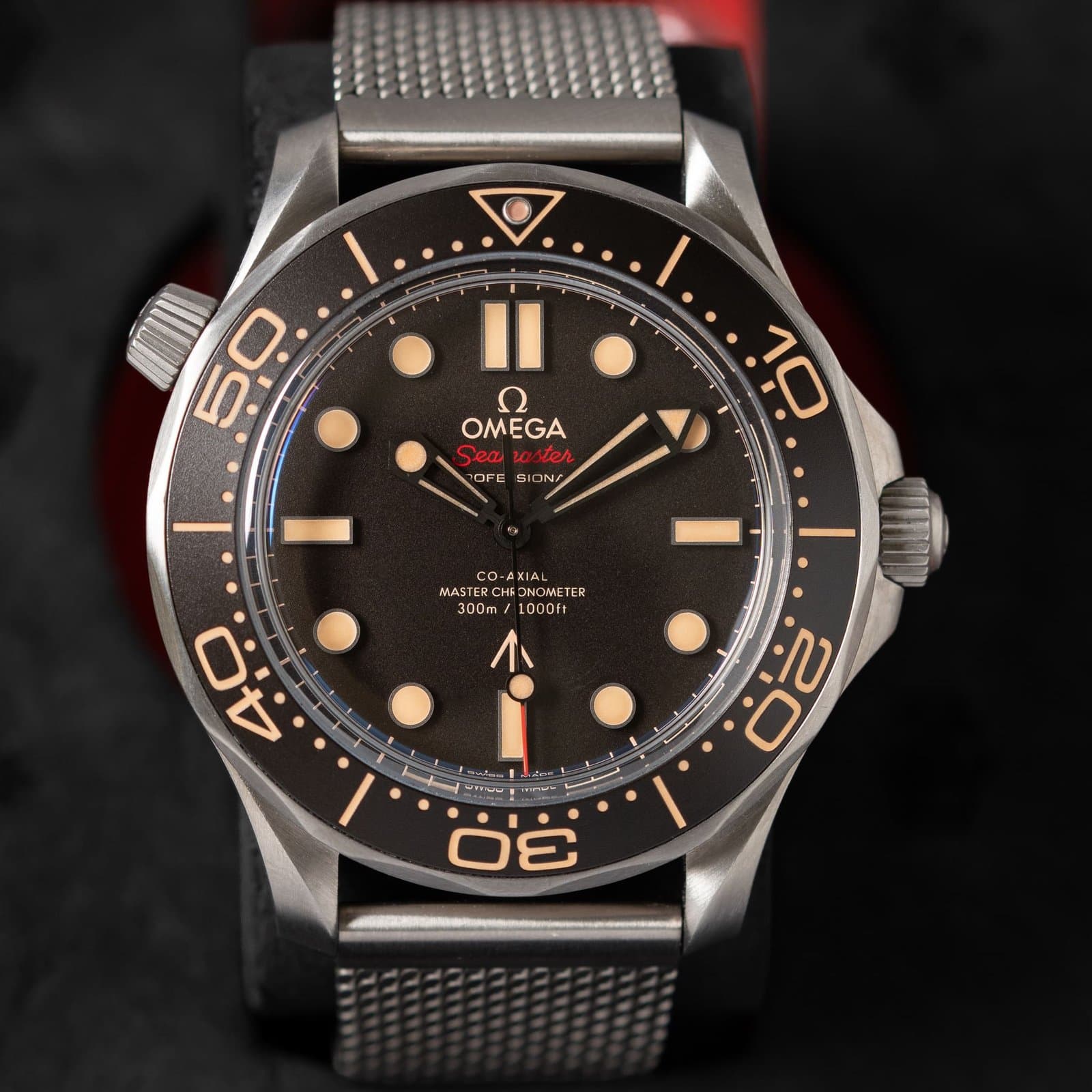 Pre-owned Omega Seamaster Diver 300M No Time To Die in titanium, front view, with a tropical brown dial, brown bezel, cream lume and a titanium mesh bracelet