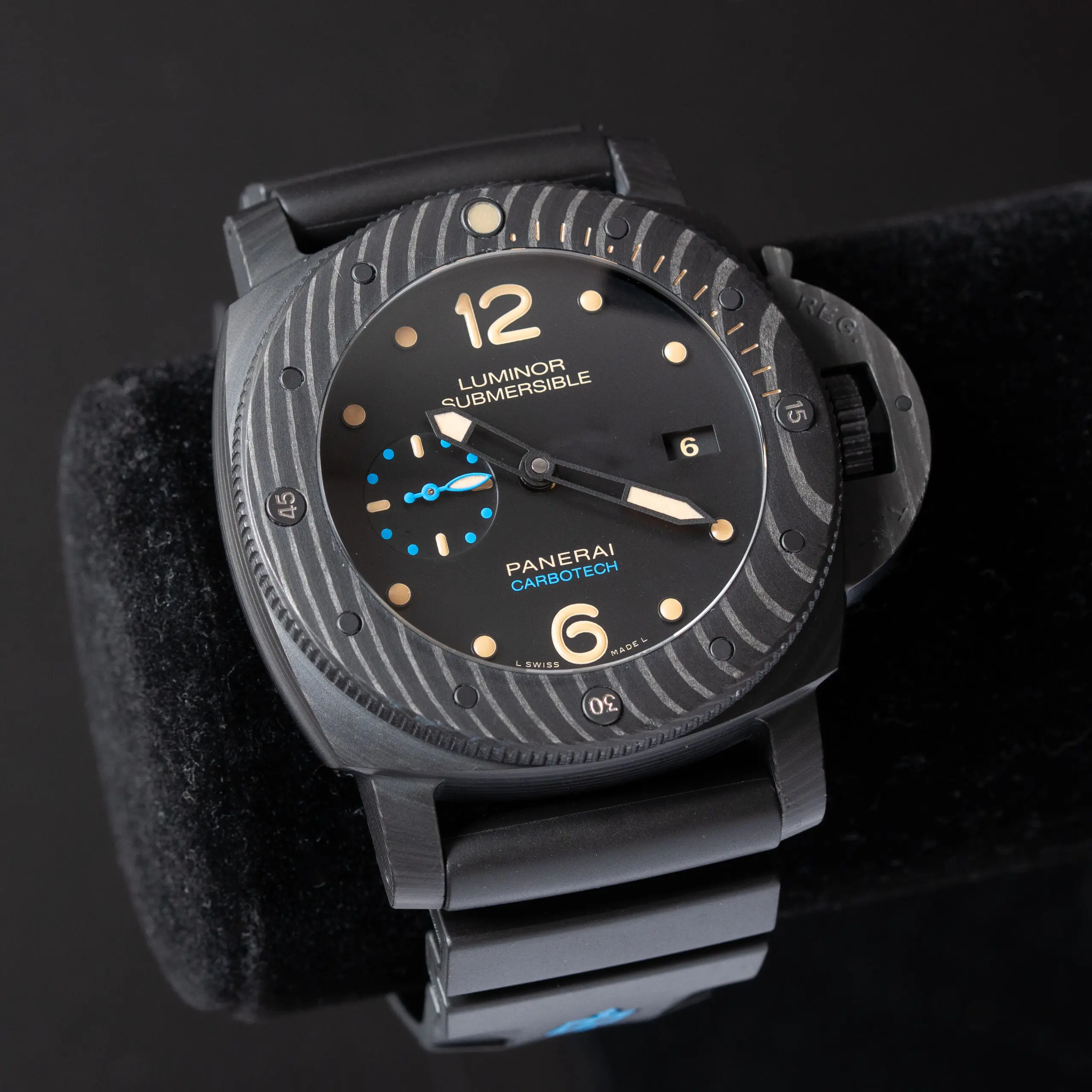 Black Panerai luxury watch with cushion-shaped case and rubber strap photographed on a dark background