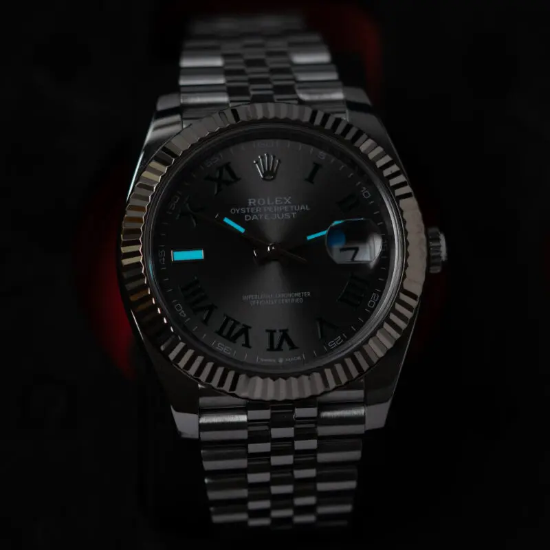 Rolex Datejust Wimbledon dial glowing in the dark, showing green Super-LumiNova hour markers and hands